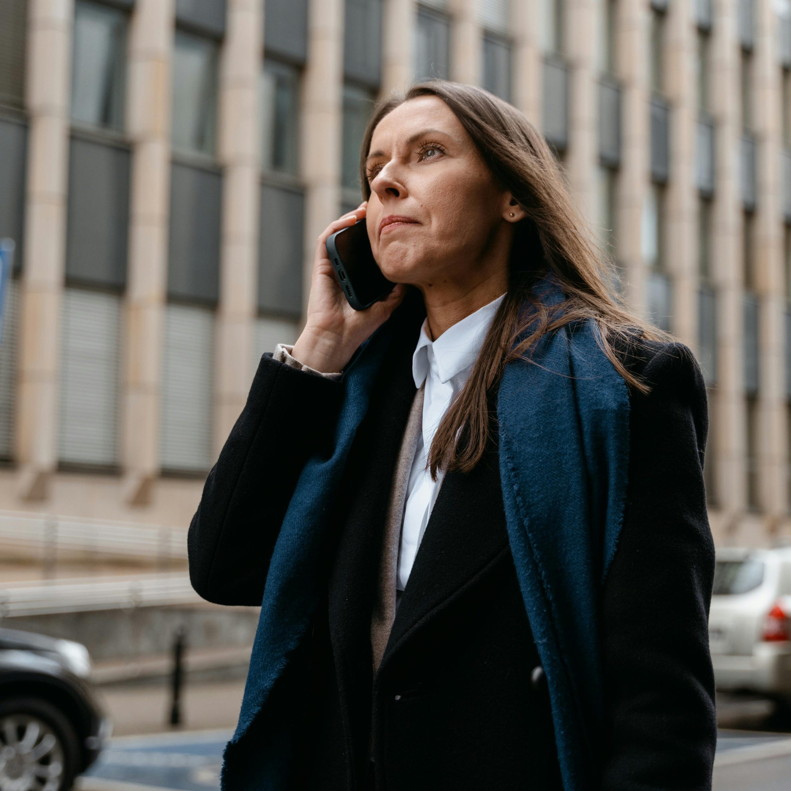 Une femme d'affaire en noir et bleu au téléphone.